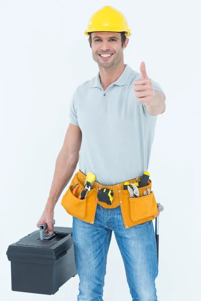 Handyman mostrando pulgares hacia arriba sosteniendo caja de herramientas — Foto de Stock