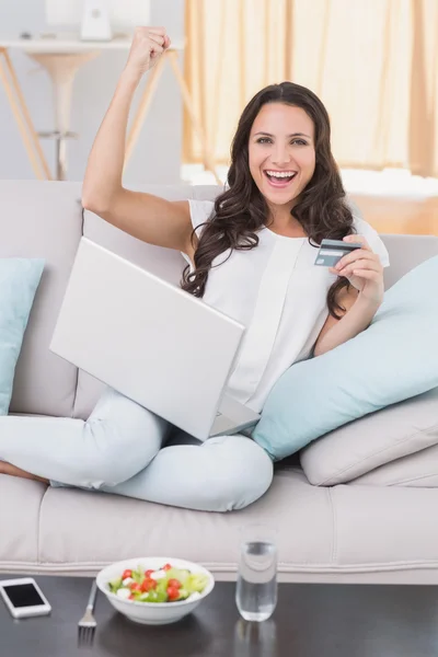 Brünette shoppen online auf der Couch — Stockfoto