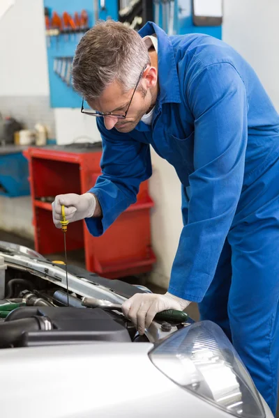 Mechanic checking the oil of car — Stock Photo, Image