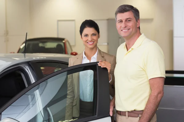 Femme d'affaires montrant l'intérieur de la voiture au client — Photo