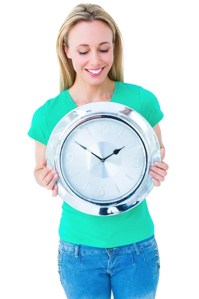 Blondýnka v neformálním oblečení drží hodiny — Stock fotografie