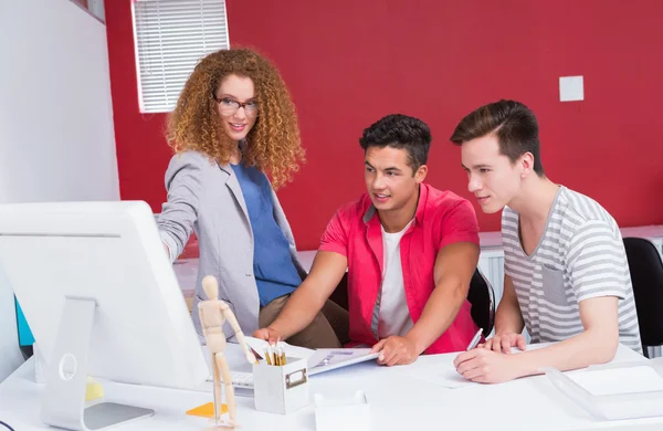 Smiling students working together on computer — Stock Photo, Image