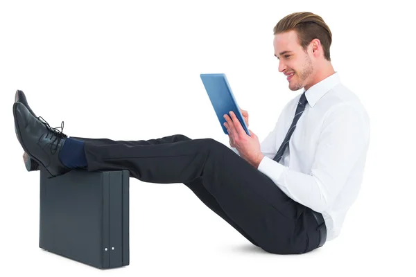 Empresario tocando la tableta con los pies en el maletín — Foto de Stock