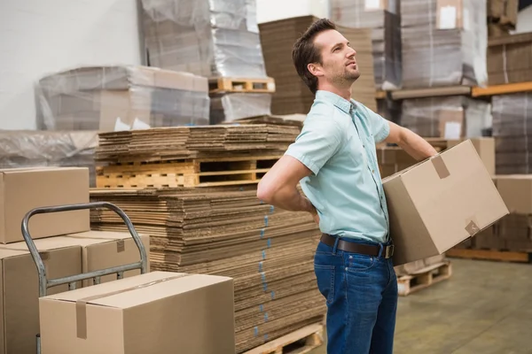 Arbeiter trägt Karton im Lager — Stockfoto