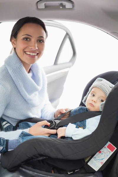 Anya gyermekével az autó ülés biztosítása — Stock Fotó