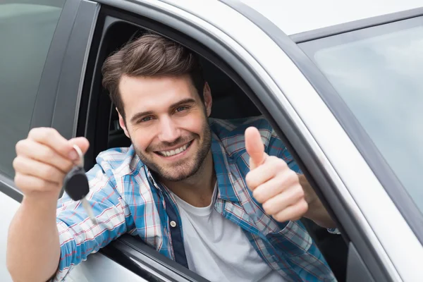 Jonge man glimlachend en met de sleutel Rechtenvrije Stockfoto's