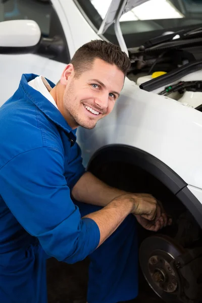 Smiling mechanic adjusting the wheel Stock Picture