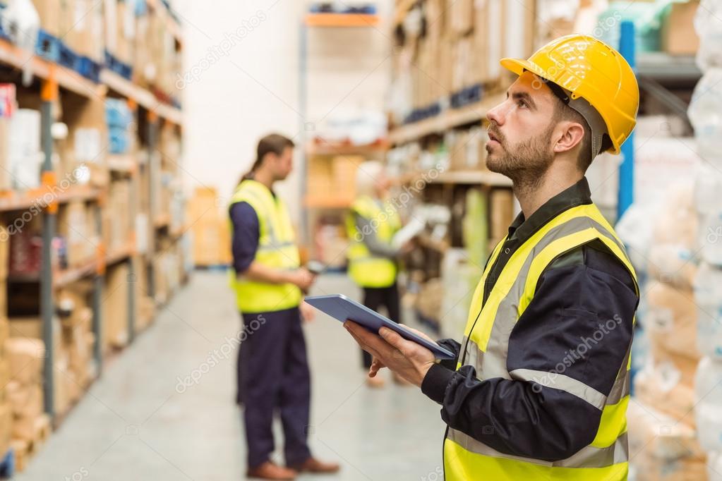 Focused warehouse manager writing on clipboard — Stock Photo