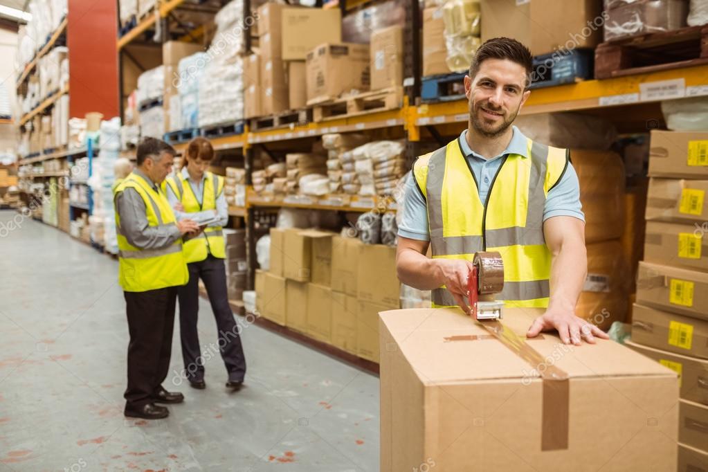Smiling warehouse workers preparing a shipment Stock Photo by