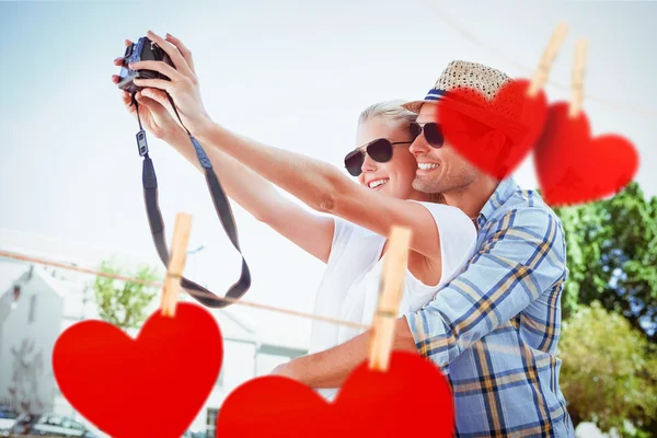 Ζευγάρι που αναλαμβάνει μια selfie εναντίον καρδιές — Φωτογραφία Αρχείου