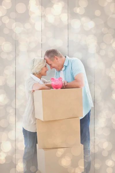 Couple with moving boxes and piggy bank — Stock Photo, Image