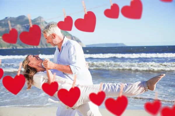 Pareja bailando en la playa juntos contra corazones — Foto de Stock