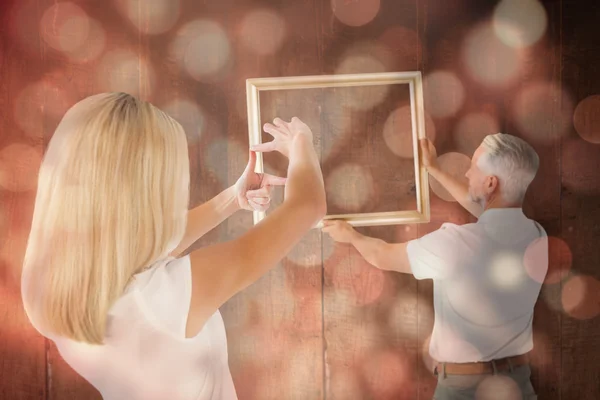 Couple hanging a frame together — Stock Photo, Image