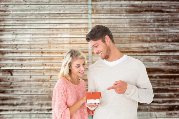 Casal segurando modelo de casa em miniatura — Fotografia de Stock