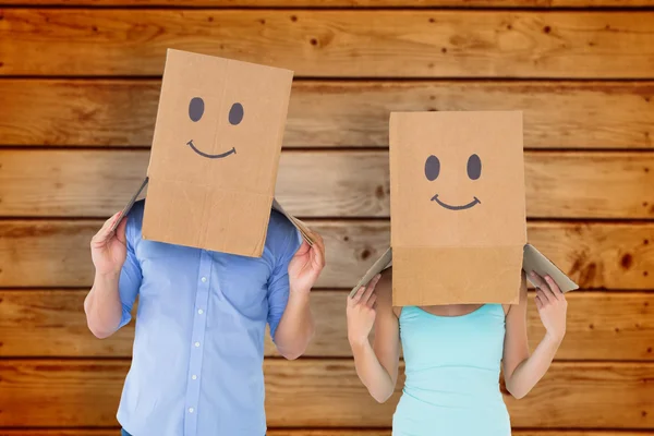 Couple wearing emoticon face boxes — Stock Photo, Image