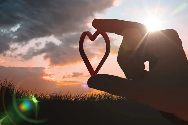 Man measuring heart  against sunset — Stock Photo, Image