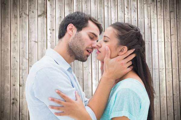 Paar küsst sich gegen Holzplanken — Stockfoto