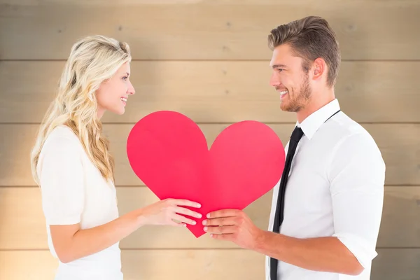 Attractive young couple holding red heart — Stock Photo, Image