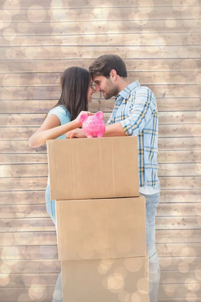 Casal com caixas móveis e mealheiro — Fotografia de Stock