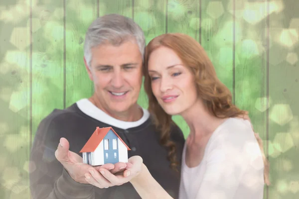 Casual couple holding small house — Stock Photo, Image