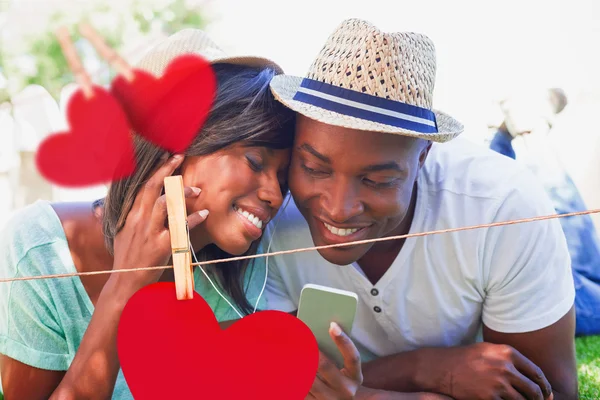 Couple couché dans le jardin écoutant de la musique — Photo