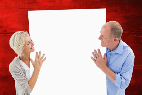 Pareja madura sonriendo y sosteniendo la tarjeta —  Fotos de Stock