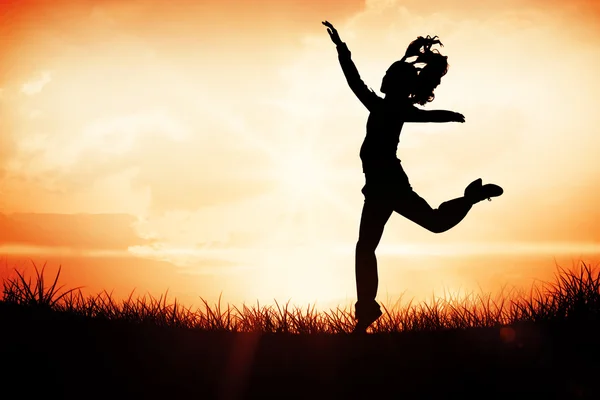 Vrouw springen tegen oranje zonsopgang — Stockfoto