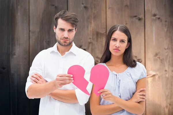 Pareja sosteniendo dos mitades de corazón roto — Foto de Stock