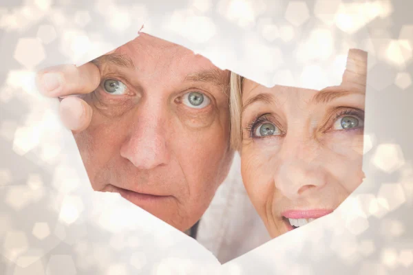 Older couple looking through rip — Stock Photo, Image