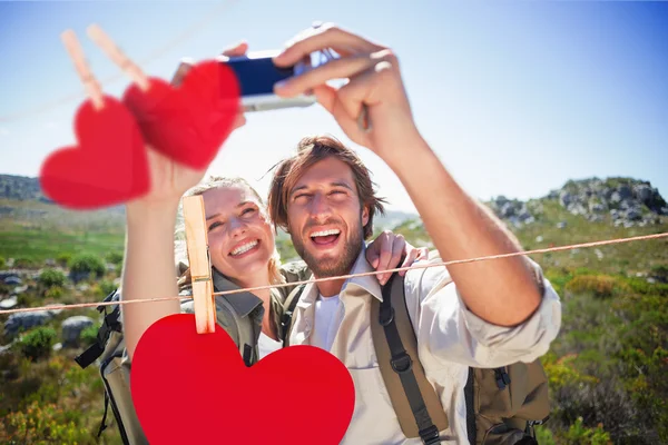 Couple debout sur un terrain de montagne prenant un selfie — Photo