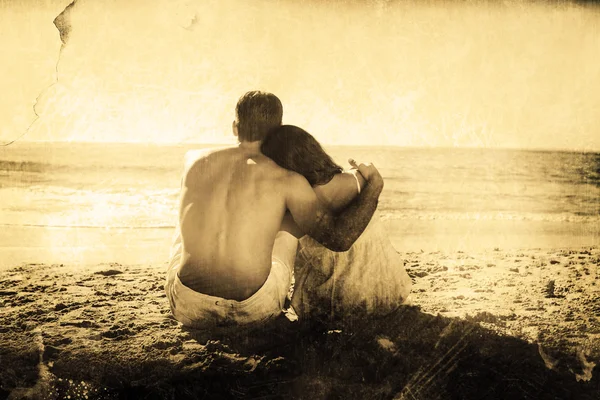 Paret sitter på sanden tittar på havet — Stockfoto