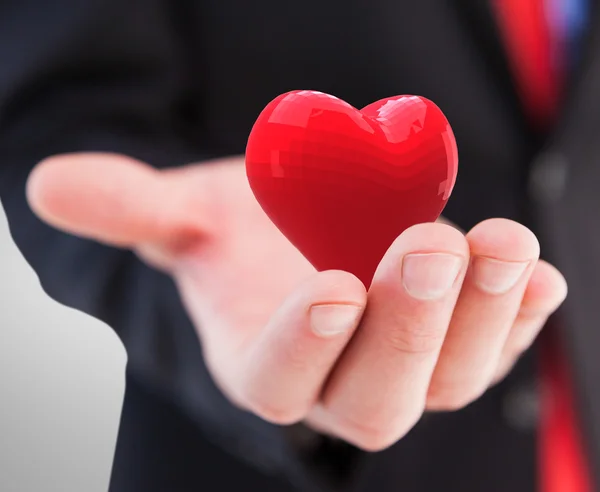 Geschäftsmann schenkt Herz mit der Hand — Stockfoto