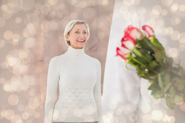 Man hiding bouquet of roses from older woman — Stock Photo, Image