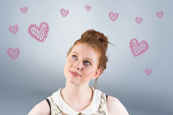 Redhead looking up thinking against grey vignette — Stock Photo, Image