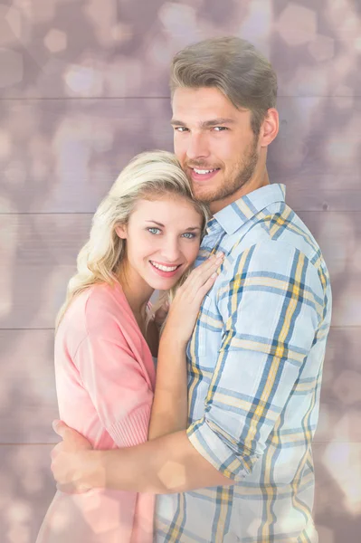 Casal atraente abraçando e sorrindo para a câmera — Fotografia de Stock