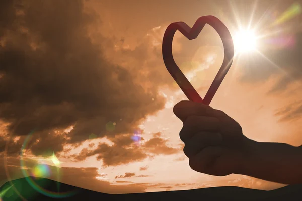 Corazón de amor rojo contra cielo nublado por la noche — Foto de Stock