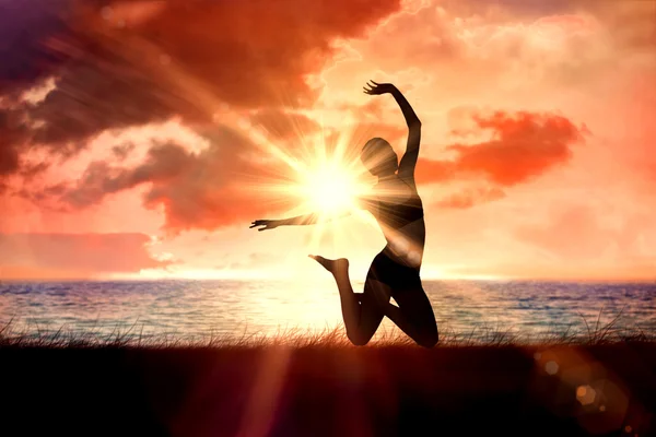 Woman jumping against sunrise — Stock Photo, Image