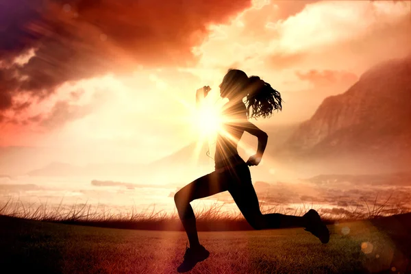 Woman jogging  against sunrise over magical sea Royalty Free Stock Images