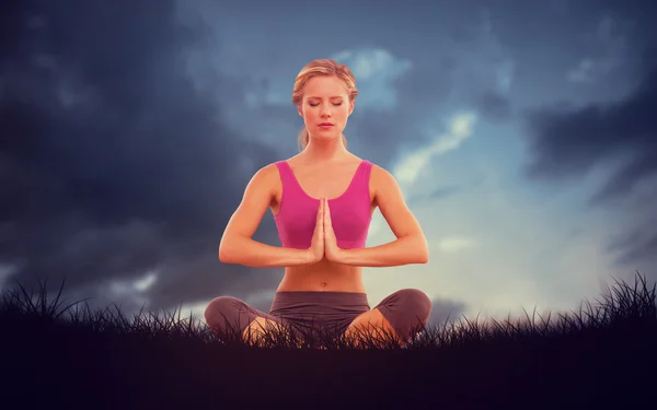 Blonde sitting in lotus pose with hands together — Stock Photo, Image