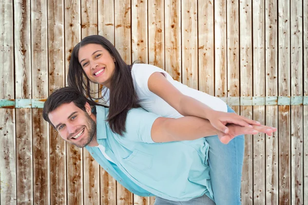 Homem dando bonito namorada porquinho de volta — Fotografia de Stock