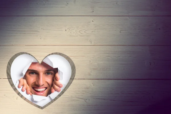 Young man looking through paper rip — Stock Photo, Image