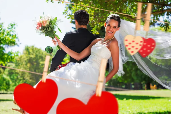 Casal sentado em scooter no parque contra corações — Fotografia de Stock