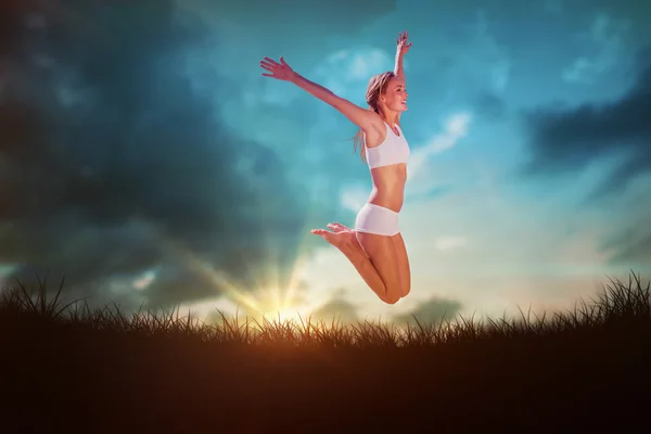 Blonde jumping with arms out — Stock Photo, Image