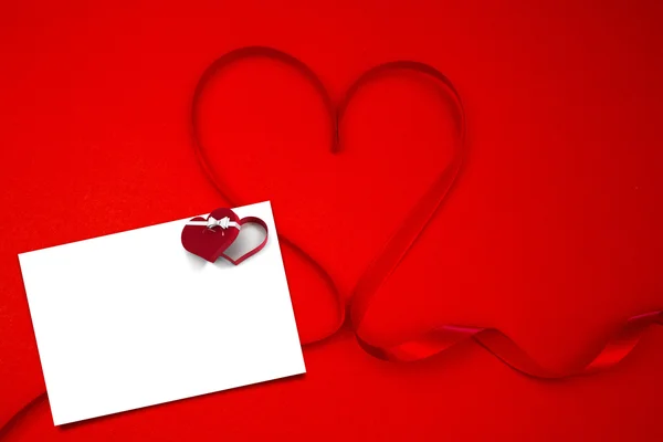 Ribbon shaped into a heart against card — Stock Photo, Image