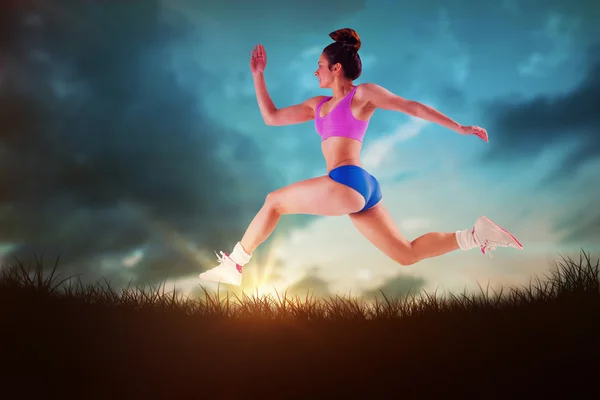 Fit brunette running and jumping — Stock Photo, Image