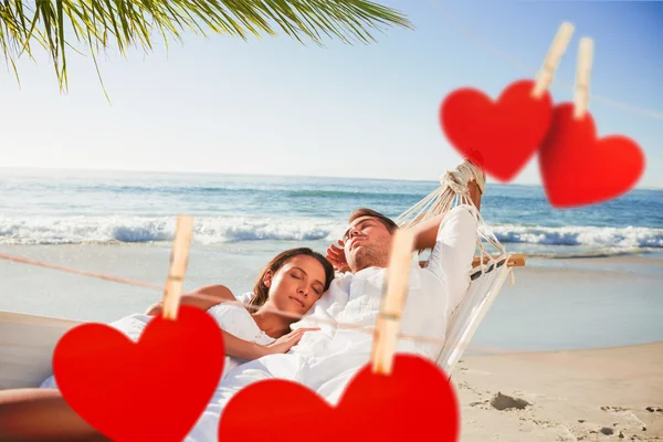 Couple napping in a hammock against hearts — Stock Photo, Image