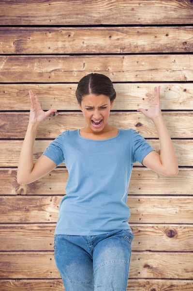 Brunette gebaren tegen houten planken — Stockfoto