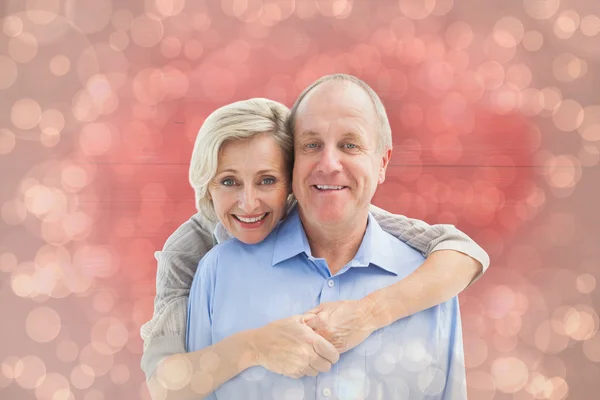 Pareja madura abrazando sonriendo a la cámara — Foto de Stock