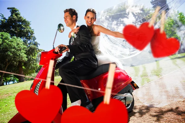 Пара, наслаждающаяся скутером против сердец — стоковое фото