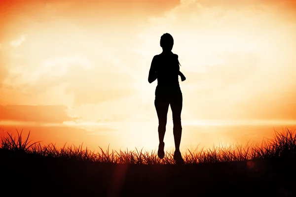 Femme jogging contre orange lever de soleil — Photo